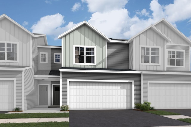 multi unit property with board and batten siding, an attached garage, and asphalt driveway