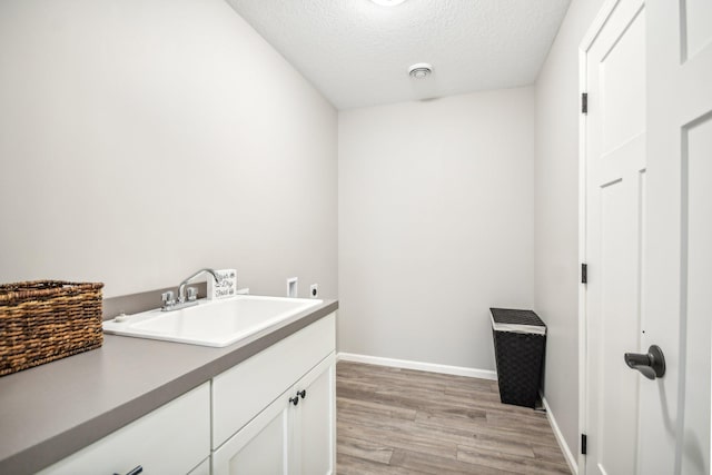 20074 Fitzgerald Trl N, Forest Lake, MN 55025 - clothes washing area with cabinet space, light wood finished floors, electric dryer hookup, a textured ceiling, and baseboards