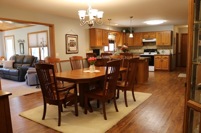 dining space featuring wood finished floors and a chandelier