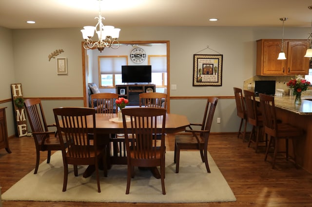 dining space with dark wood-style flooring, a chandelier, and recessed lighting