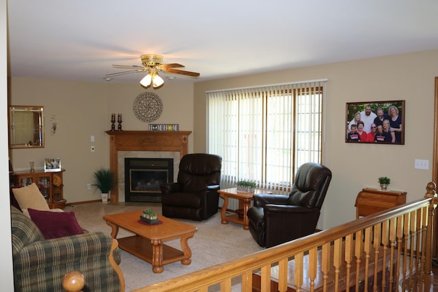 living room with light colored carpet, a ceiling fan, and a fireplace with flush hearth