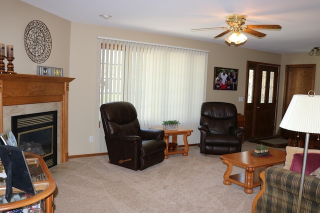 living room featuring light colored carpet, a ceiling fan, a fireplace, and baseboards