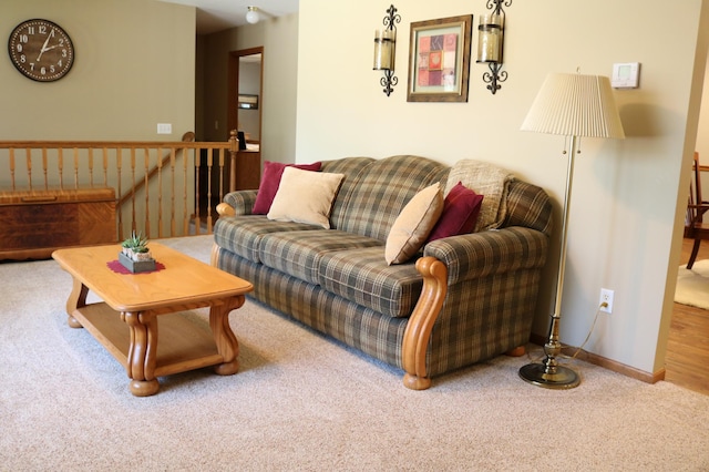 carpeted living area featuring baseboards