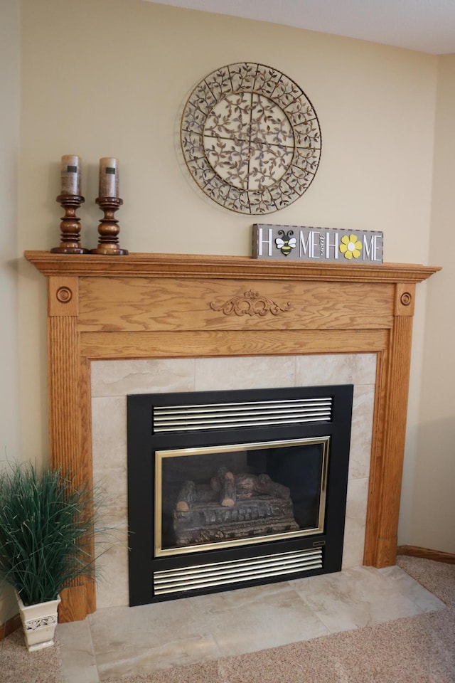 detailed view of a premium fireplace, carpet flooring, and baseboards