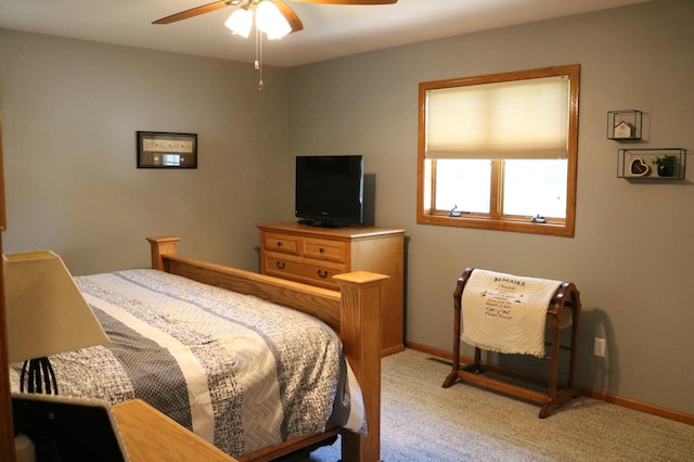 bedroom with light colored carpet, baseboards, and a ceiling fan