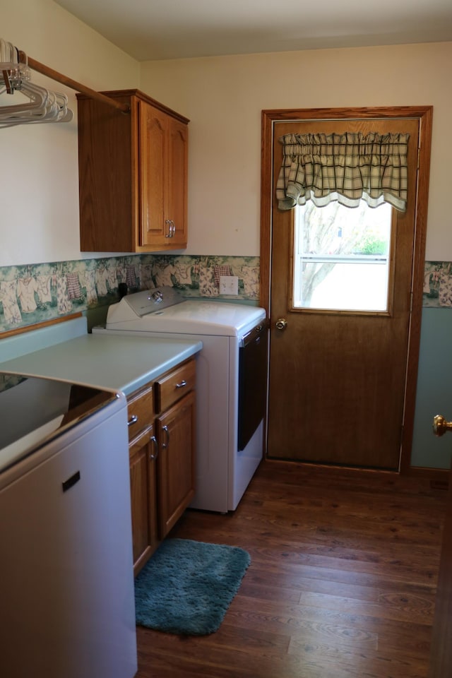 washroom featuring cabinet space, washing machine and clothes dryer, and dark wood-style flooring