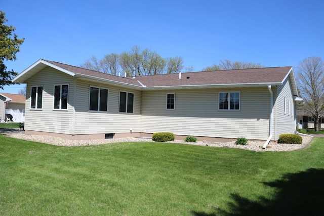 rear view of property featuring a lawn