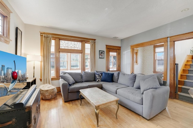 living area featuring light wood-style flooring and stairway