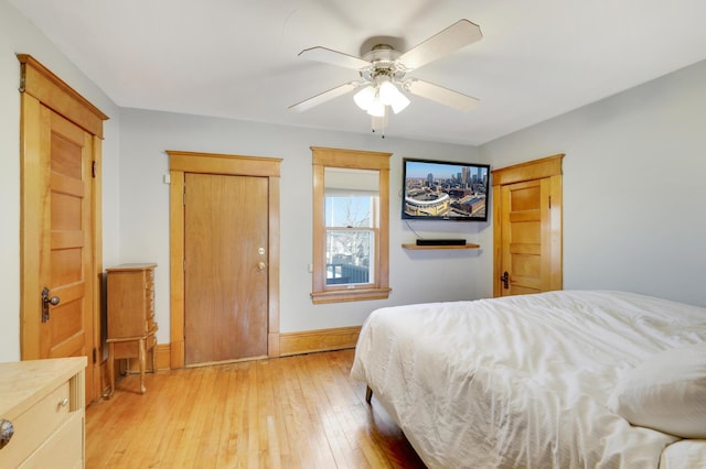 bedroom with light wood-style flooring, baseboards, and ceiling fan