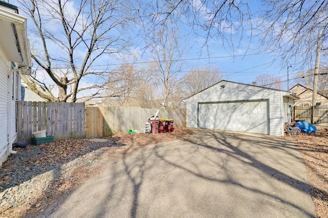 view of yard with an outdoor structure, a detached garage, and fence