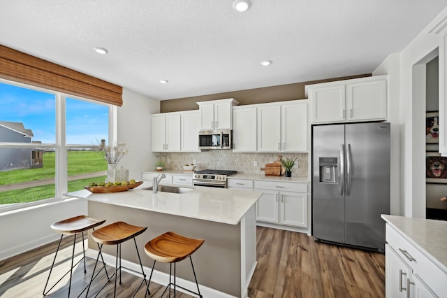 2461 Jandell Ave NE, Saint Michael, MN 55376 - kitchen featuring appliances with stainless steel finishes, wood finished floors, decorative backsplash, light countertops, and white cabinetry