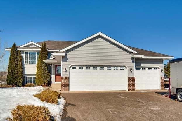 view of front of home with an attached garage, brick siding, and driveway