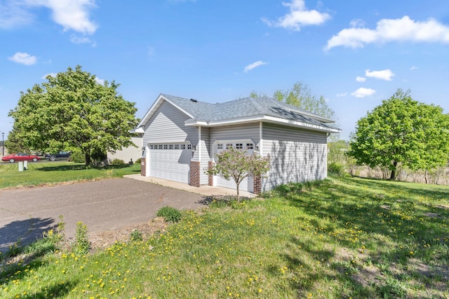 7724 385th St, North Branch, MN 55056 - view of home's exterior with a yard, asphalt driveway, an attached garage, and a shingled roof