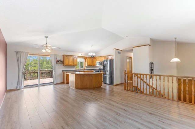 7724 385th St, North Branch, MN 55056 - kitchen with stainless steel appliances, vaulted ceiling, a center island, a ceiling fan, and light wood finished floors