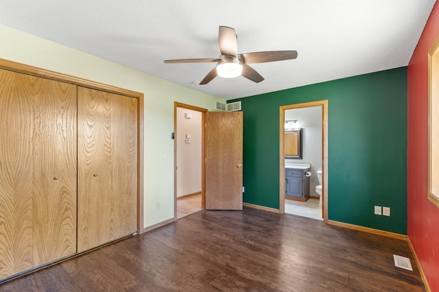 7724 385th St, North Branch, MN 55056 - unfurnished bedroom with dark wood-style flooring, baseboards, a closet, ensuite bathroom, and a ceiling fan