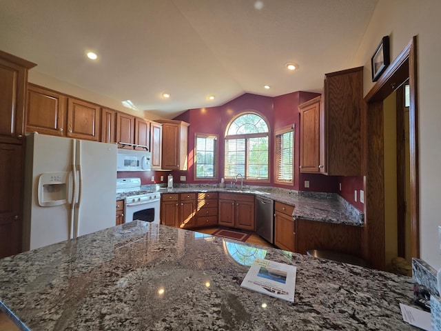 1073 Harvest Way, Lake City, MN 55041 - kitchen with white appliances, vaulted ceiling, dark stone countertops, brown cabinetry, and a sink