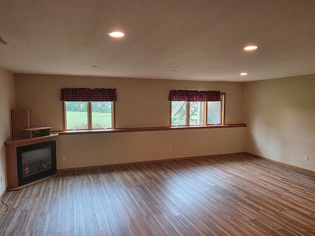 1073 Harvest Way, Lake City, MN 55041 - unfurnished living room featuring healthy amount of natural light, a glass covered fireplace, wood finished floors, and recessed lighting