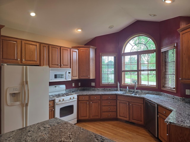 1073 Harvest Way, Lake City, MN 55041 - kitchen with white appliances, brown cabinetry, vaulted ceiling, light wood finished floors, and dark stone countertops
