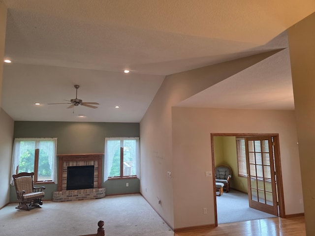 1073 Harvest Way, Lake City, MN 55041 - unfurnished living room featuring plenty of natural light, a fireplace, a ceiling fan, vaulted ceiling, and light carpet