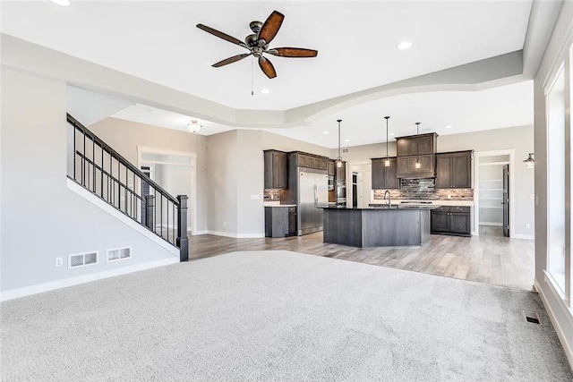 kitchen featuring built in refrigerator, open floor plan, a ceiling fan, light colored carpet, and recessed lighting