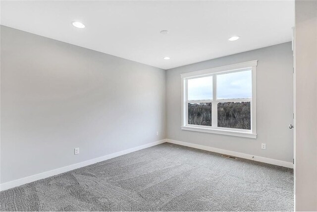 carpeted empty room featuring baseboards and recessed lighting