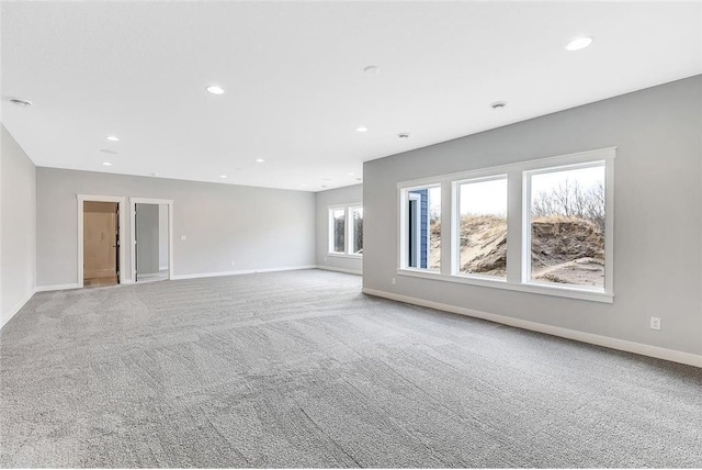 unfurnished living room with carpet, baseboards, and recessed lighting