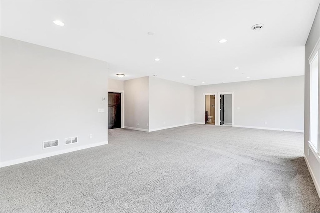 spare room featuring light colored carpet, baseboards, and recessed lighting