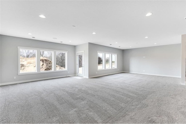 unfurnished living room featuring carpet, recessed lighting, and baseboards