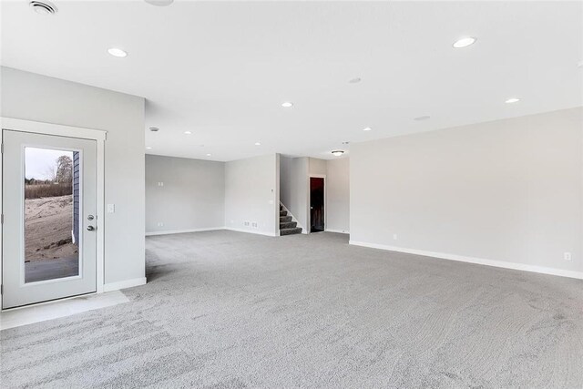 spare room with carpet floors, recessed lighting, stairway, and baseboards