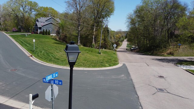 view of asphalt road with traffic signs and curbs