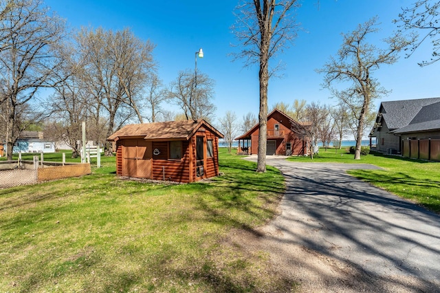 37009 Blarney Beach Rd, Everts Twp, MN 56515 - rear view of house featuring an outbuilding, a yard, a garage, and driveway