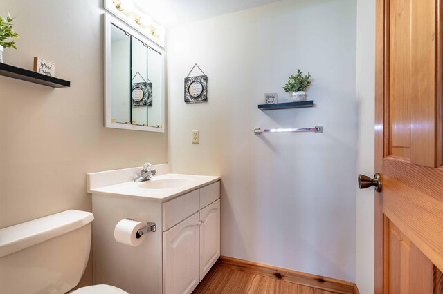 37009 Blarney Beach Rd, Everts Twp, MN 56515 - bathroom with wood finished floors, toilet, vanity, and baseboards