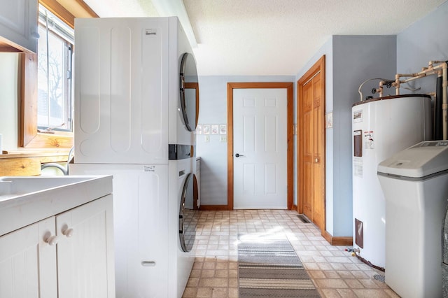 37009 Blarney Beach Rd, Everts Twp, MN 56515 - laundry room with stacked washer / drying machine, baseboards, water heater, and a textured ceiling