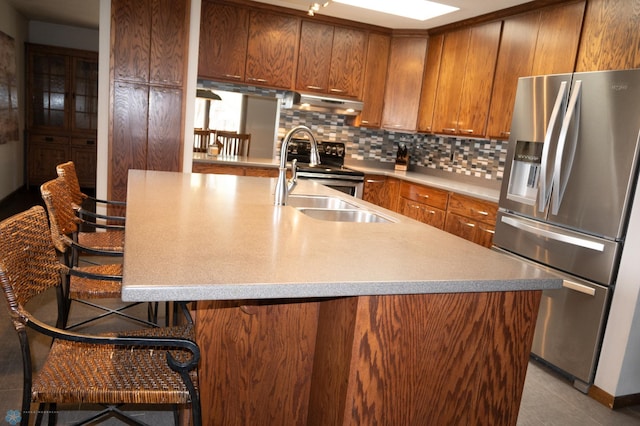 130 Woodcrest Dr N, Fargo, ND 58102 - kitchen featuring stainless steel appliances, under cabinet range hood, a sink, and brown cabinets