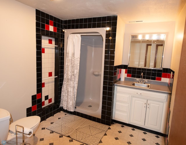 130 Woodcrest Dr N, Fargo, ND 58102 - full bathroom featuring tile walls, a shower stall, toilet, and vanity