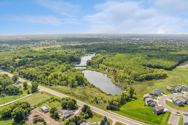 drone / aerial view of a large body of water and a heavily wooded area