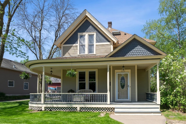 1112 4th St S, Stillwater, MN 55082 - victorian home featuring a porch, a front lawn, a shingled roof, and a chimney