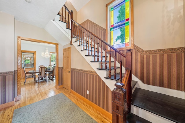 1112 4th St S, Stillwater, MN 55082 - stairs with a wainscoted wall, hardwood / wood-style flooring, a chandelier, and wallpapered walls