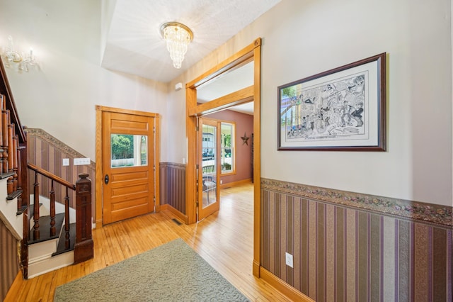 1112 4th St S, Stillwater, MN 55082 - entrance foyer featuring wainscoting, wood finished floors, stairway, and a chandelier