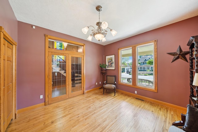 1112 4th St S, Stillwater, MN 55082 - sitting room with light wood-type flooring, a chandelier, baseboards, and french doors