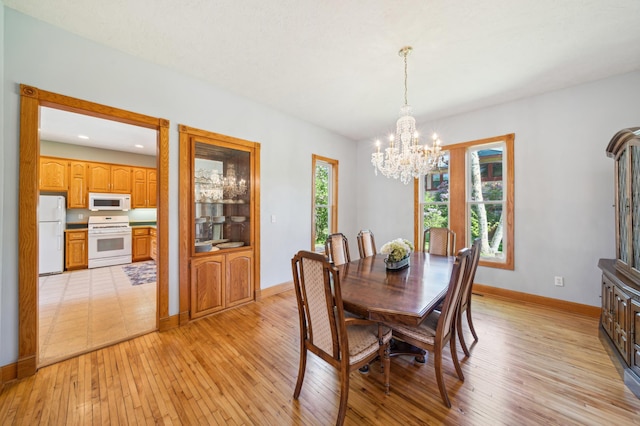 1112 4th St S, Stillwater, MN 55082 - dining area with a chandelier, light wood-style floors, and baseboards