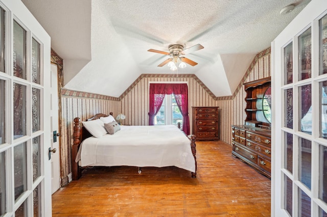 1112 4th St S, Stillwater, MN 55082 - bedroom with wood finished floors, a textured ceiling, lofted ceiling, french doors, and a ceiling fan