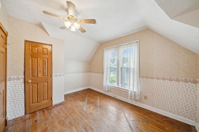 1112 4th St S, Stillwater, MN 55082 - additional living space with wood-type flooring, vaulted ceiling, wainscoting, a ceiling fan, and wallpapered walls