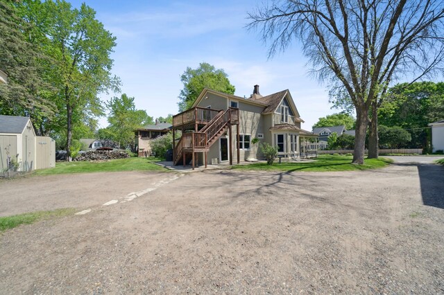 1112 4th St S, Stillwater, MN 55082 - view of front of home with stairway, a deck, a chimney, and driveway