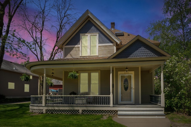 1112 4th St S, Stillwater, MN 55082 - victorian house featuring covered porch, a front lawn, a chimney, and roof with shingles