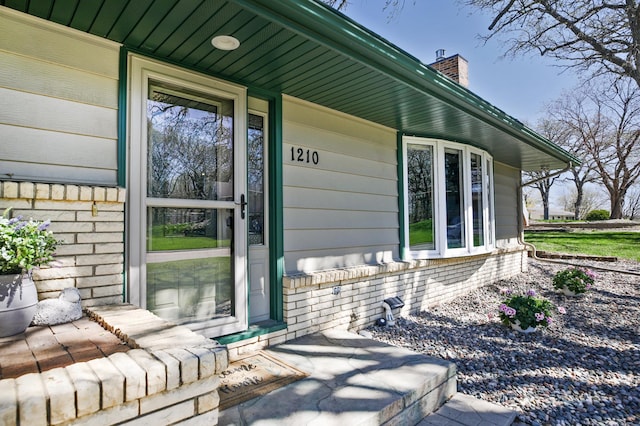 view of home's exterior featuring a chimney and covered porch