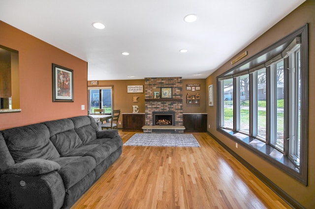 living room featuring light wood finished floors, recessed lighting, and a fireplace