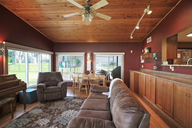 living room with track lighting, healthy amount of natural light, light wood finished floors, wooden ceiling, and vaulted ceiling