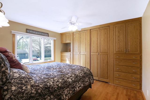 bedroom with light wood-style floors and a ceiling fan