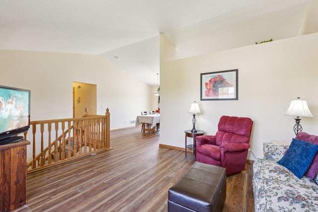 living area with lofted ceiling, wood finished floors, and baseboards